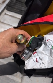 Picture of a canister being held in someone hand showing a puncture in the canister.