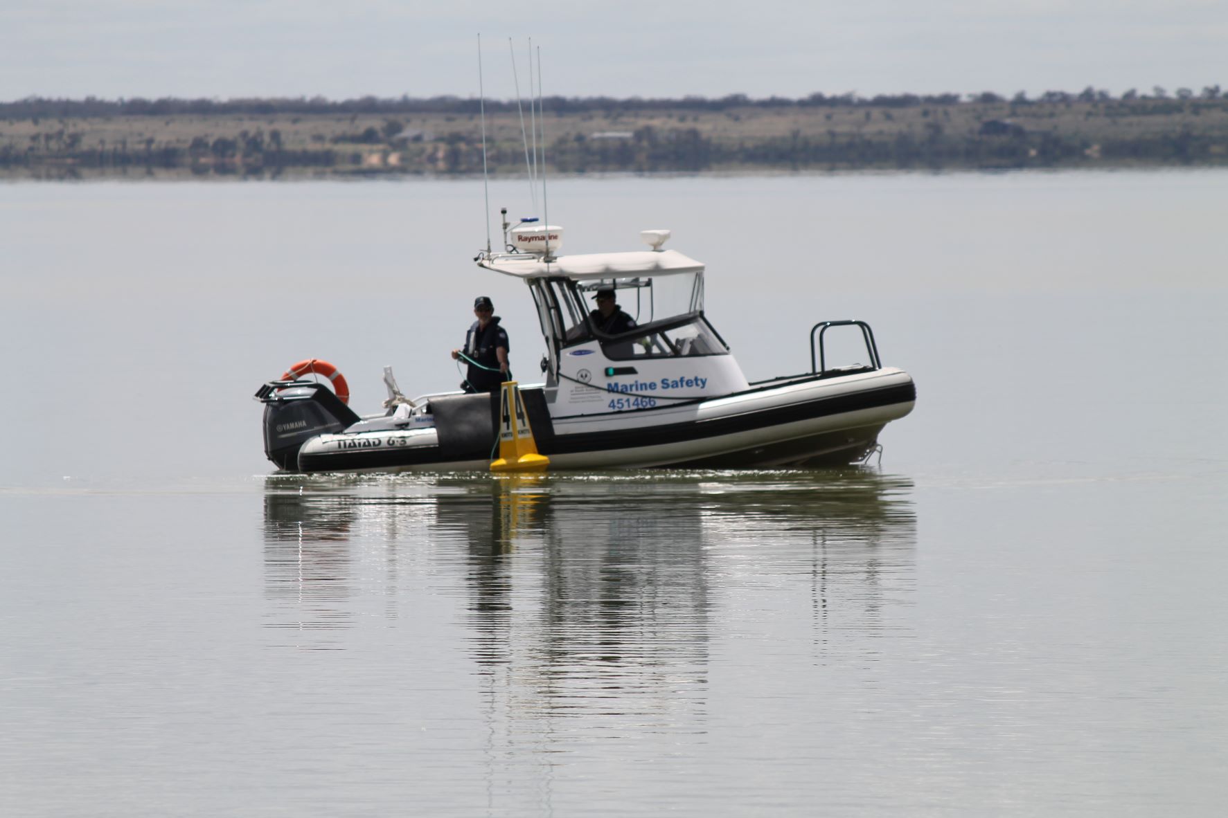 Marine Safety Boat on Murray River deploying a yellow 4 knot buoy