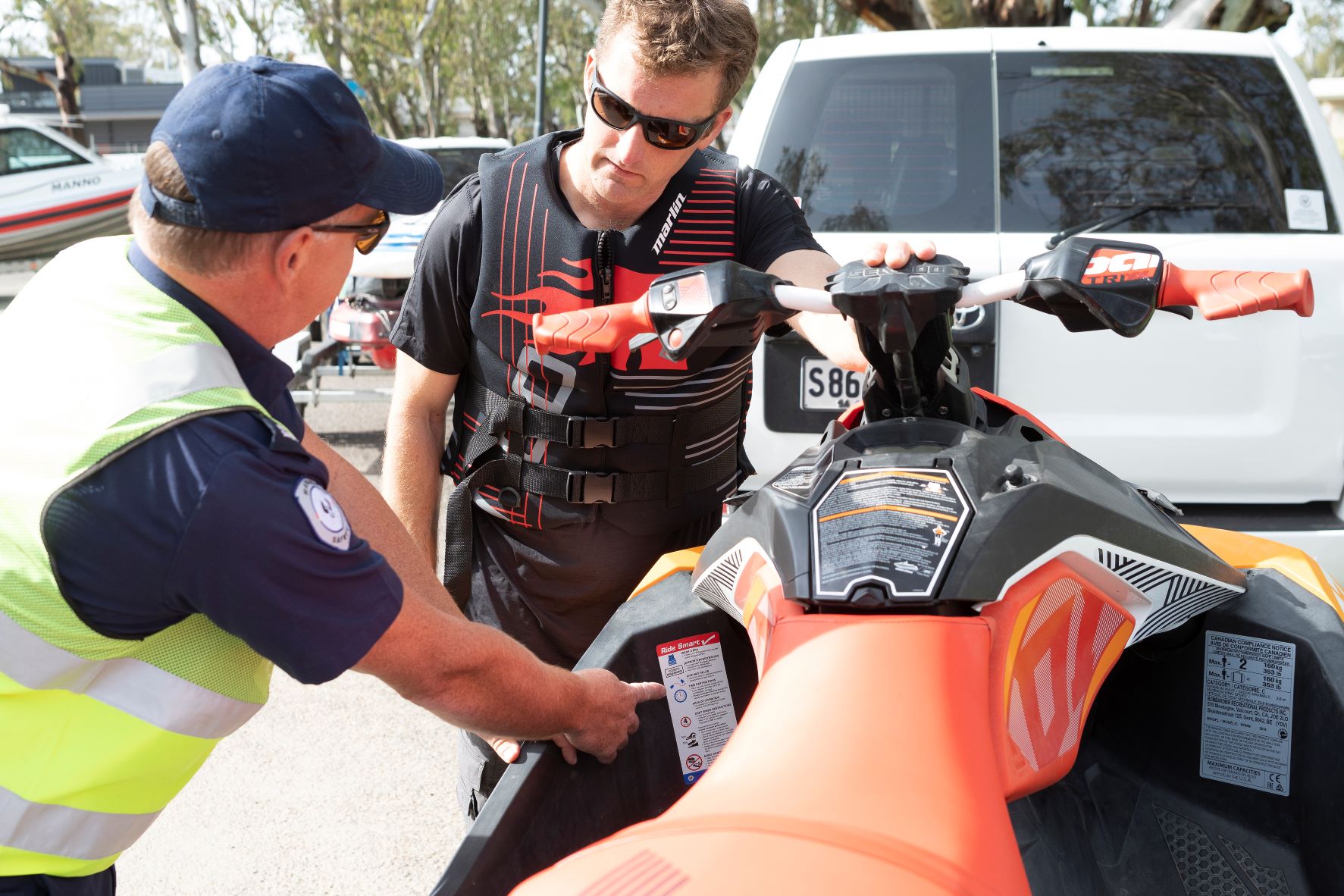 Marine Safety Officer checking ride smart sticker on a jetski with a jet ski operator looking on