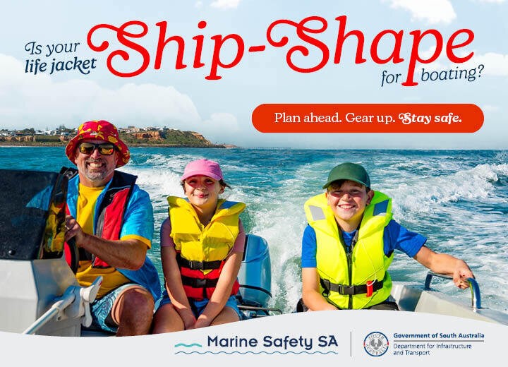 Photo of one adult on the left wearing a bright blue and yellow shirt with a red hat and two children on the boat next to him with big smiles enjoying the water. all the people are fitted with a lifejacket and the wake wash in the background with green cliff sides to the left