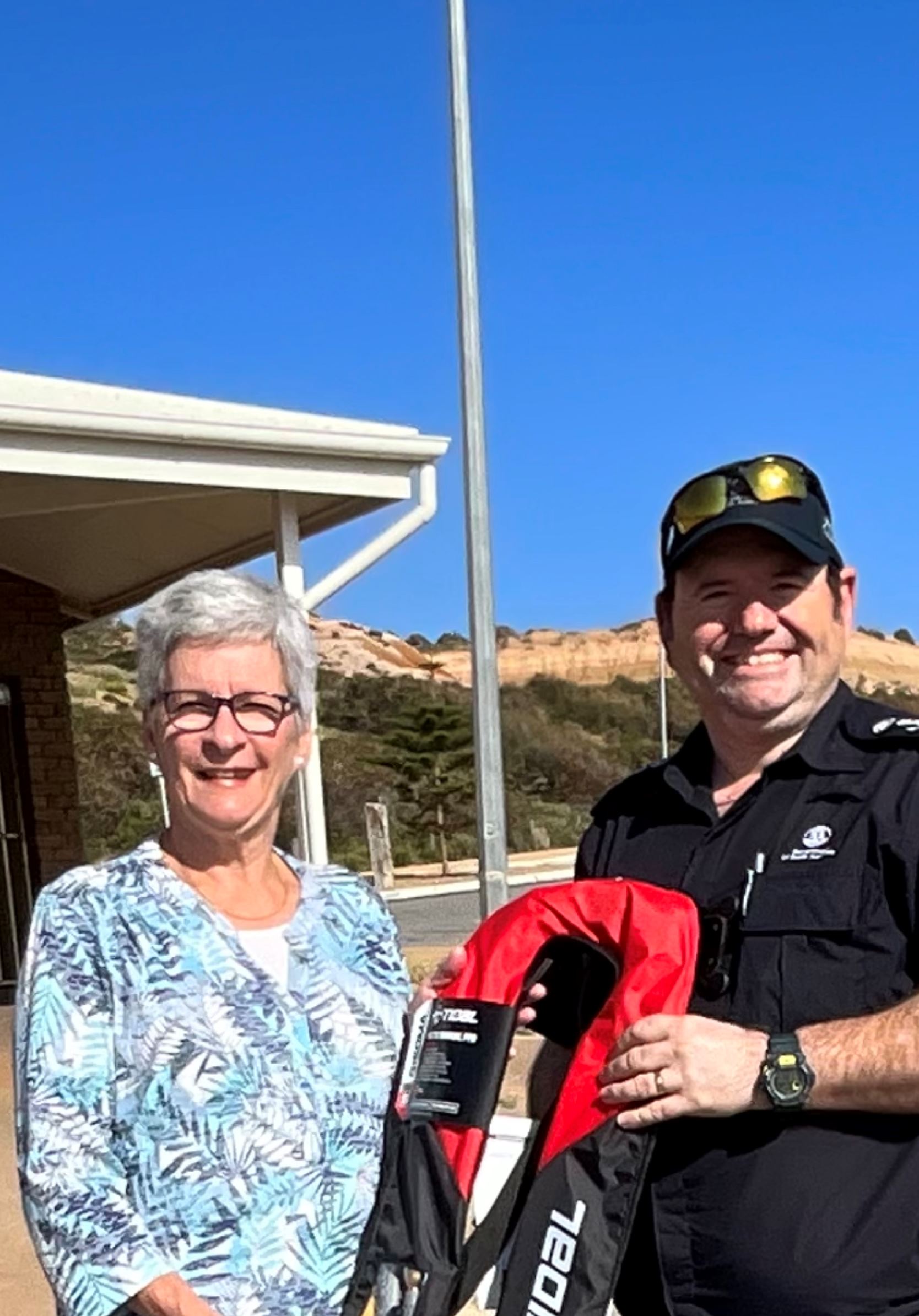 Pictured is a Marine Safety officer handing a lady of the name Beverley her lifejacket she had won from going into the draw at the boat show.