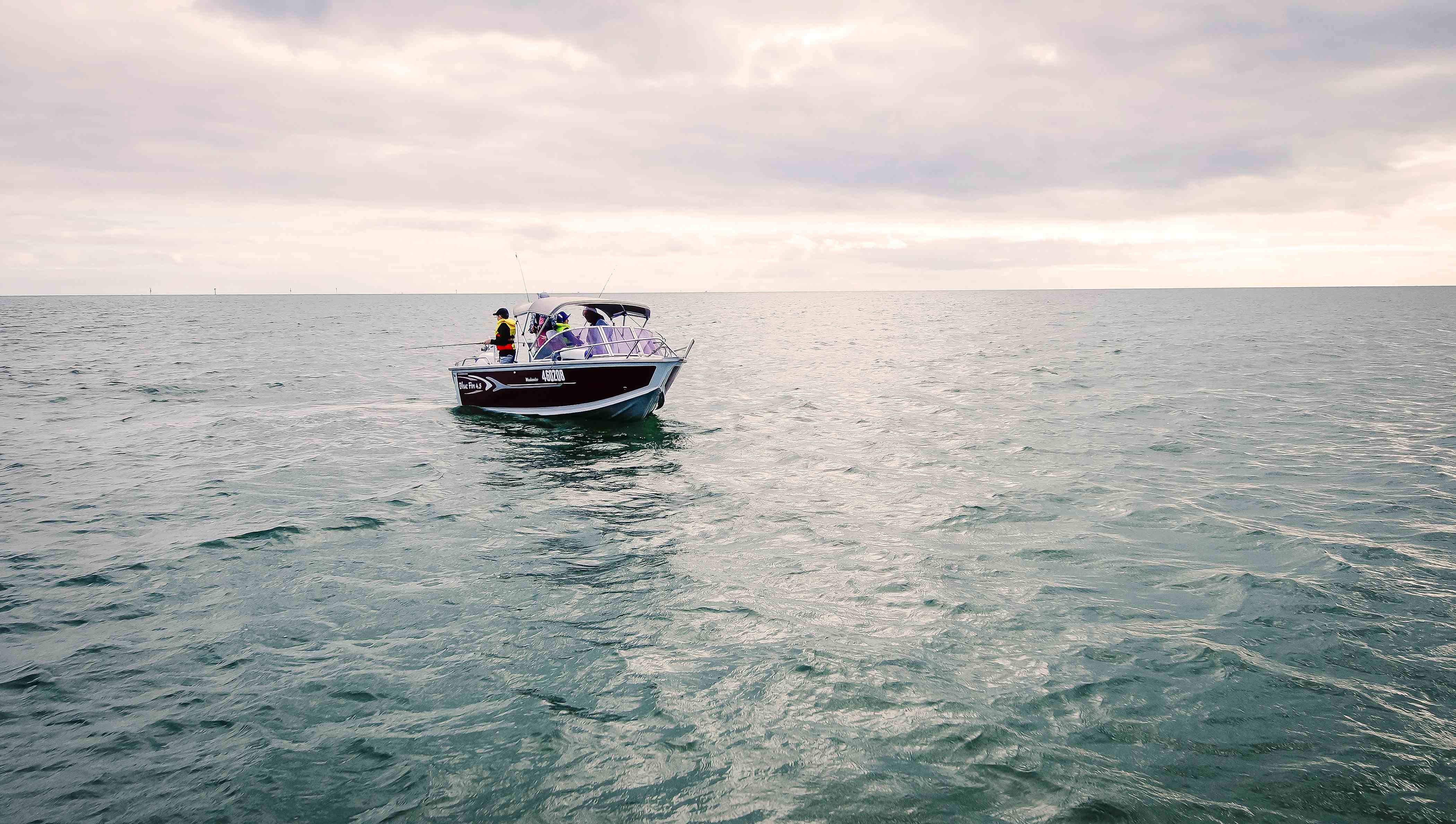 Boat on the ocean with people fishing from it