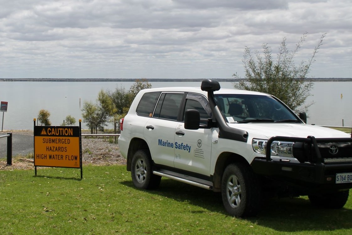 Marine Safety SA car next to a hazard sign on the banks of the River Murray
